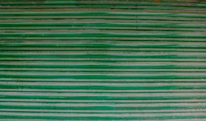 Obraz premium green old horizontal stripes of metallic blinds with rust and paint smudges