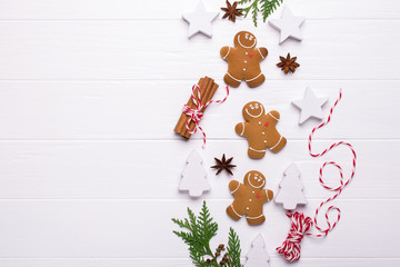 Christmas Decorative Border made of Festive Elements. Smiling gingerbread man, christmas white decorations, pine branches. . Flat lay, top view.