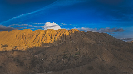 Sandy hills. Sandy canyon. Warm colors background. Yellow sandstone textured mountain, white thin sand dune, bright sky