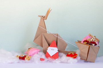 Origami papaer santa is preparing to give gifts to children to christmas day.
