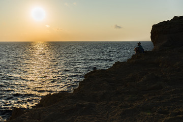 Homme qui admire le coucher de soleil