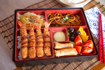 Bento box with fried prawns and noodle
