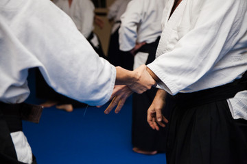 Aikidoki are fighting in aikido training. Hold the opponent's hand