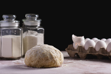 Fototapeta na wymiar dough on a dark background with ingredients