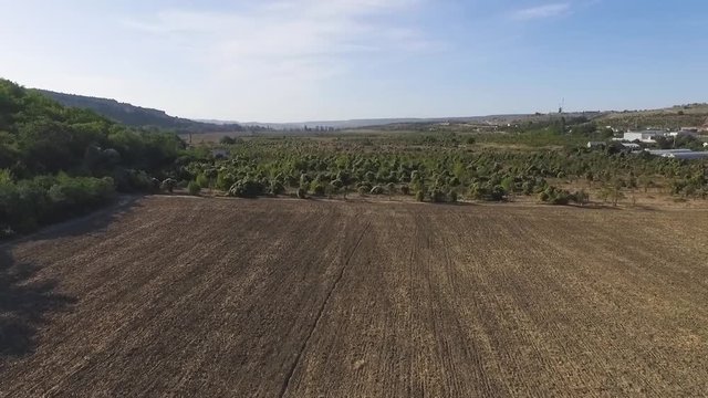 Aerial view of agricultural fields in the mountains with blue sky background. Shot