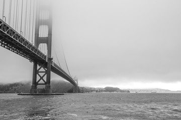 Black and white Golden Gate Bridge with fog from Fort Point, San Francisco Bay, California, United States. Symbol, icon and landmark of San Francisco. Urban BW cityscape panorama.