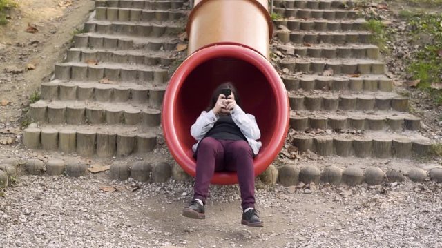 Young girl addictive to a cell phone sliding and walking away.