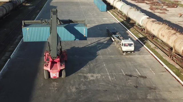 Crane loading container on truck on a logistical warehouse