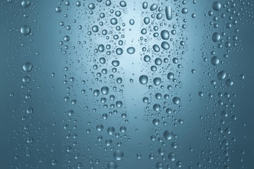 Water drops on round blue background, soft focus, close up