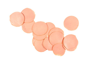 Round pieces of boiled unstructured sausage are scattered in chaotic order isolated on white background.