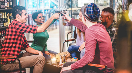 Happy friends cheering with red wine inside trendy winery bar