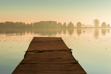 Water landscape with a wooden pier at dawn