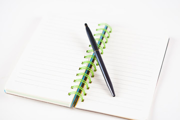 notepad with pen on white table background