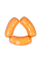 Smoked sausages lined in a triangle, isolated on a white background.