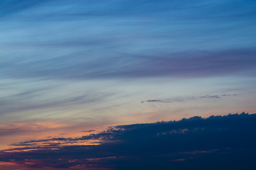 Fototapeta na wymiar Blue evening sky with blurred sun on horizon trough fence. Creative idea- underexposed photo.