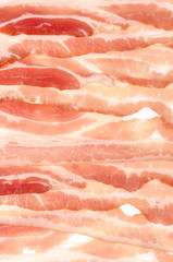 The background of thin strips of smoked bacon lie tightly together.