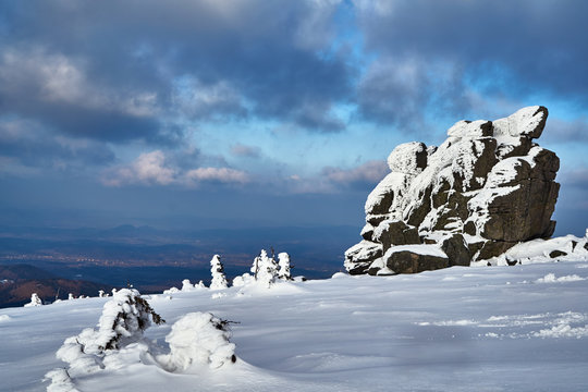 Lonely rock and snow-covered tourist trail in the Giant Mountains in Poland..