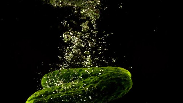 Falling of cucumbers in water. Slow motion.