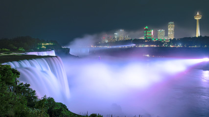 Naklejka na ściany i meble Niagara Falls lit at night by colorful lights. Niagara Falls, NY, USA.