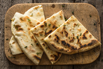 Pita bread on wooden board with feta cheese and tomatoes and pepper. Still life of food. Georgian cuisine. Spanish food. National cuisine. Traditional dish on wooden table. Mediterranean cuisine.