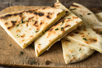 Pita bread on wooden board with feta cheese and tomatoes and pepper. Still life of food. Georgian cuisine. Spanish food. National cuisine. Traditional dish on wooden table. Mediterranean cuisine.