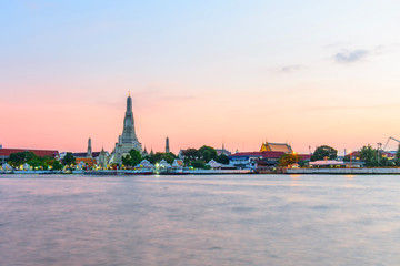 Fototapeta na wymiar Landmark Wat Arun Ratchawararam Ratchawaramahawihan with reflections on the river in sunset time