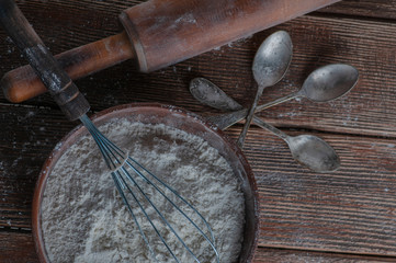 Still life with flour and spoons with a roll, a strainer. supplied on a wooden basis