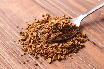  instant coffee in a spoon on a wooden background. Flavored coffee