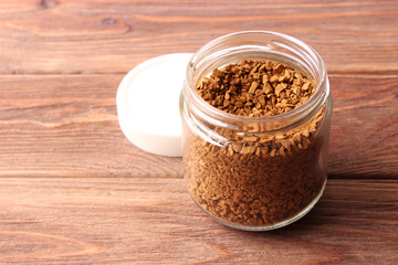  instant coffee in a glass jar on a wooden background.
