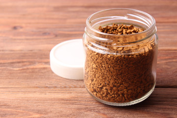  instant coffee in a glass jar on a wooden background.