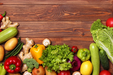 Different fresh vegetables on a wooden table top view. Proper and healthy food, diet, vegetarian. Cooking food, vegetable dishes. flat lay