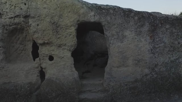Ruins of ancient town of cave-quarters inside sheer rock deserted place. Shot. Aerial view on ancient settlement in rocks and caves.