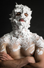 photo portrait of a strong guy smeared with shaving foam all over his face