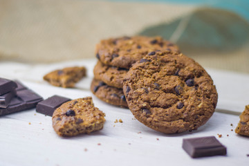 Oatmeal cookies with chocolate chips and chocolate lie on a light table.