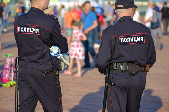 Policemans on the city street, back view