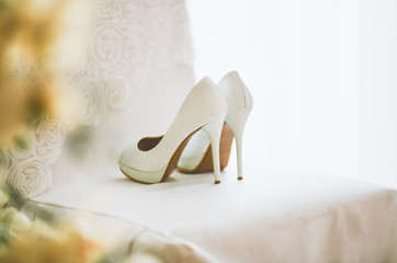 Wedding shoes stand on a white chair