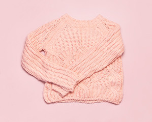 Female pink knitted sweater pullover on pastel pink background top view flat lay. Fashion Lady Clothes Set Trendy Cozy Knit Jumper Autumn winter clothes Female fashion look Lifestyle gentle background