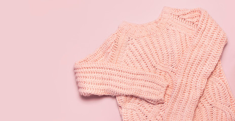 Female pink knitted sweater pullover on pastel pink background top view flat lay. Fashion Lady Clothes Set Trendy Cozy Knit Jumper Autumn winter clothes Female fashion look Lifestyle gentle background
