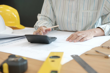 architect working on house blueprint of real estate project at workplace. engineer using...
