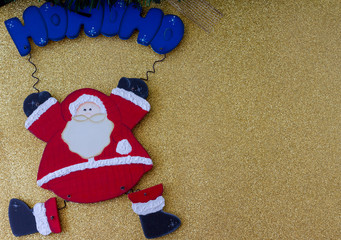 Christmas decorations. Funny Santa Claus. Merry Christmas ho ho ho greeting message. Golden background. Top view. Copy Space