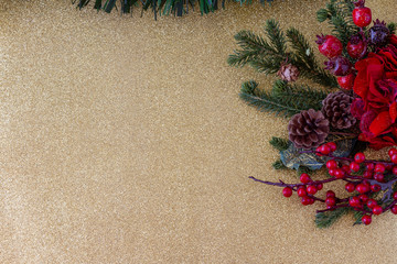 Christmas frame composition.  Decorations Mistletoe, holly, garlands and green tinsel. Golden background . Top view. Copy Space