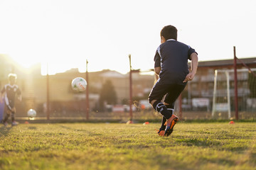 Naklejka premium Children football team in training at sunset 