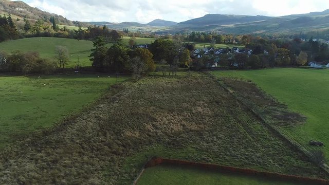 Aerial footage over the rural village of Fintry with views to the Campsie Fells. Ascending.