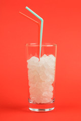 A glass of sugar cubes is a concept of unhealthy food. On red background