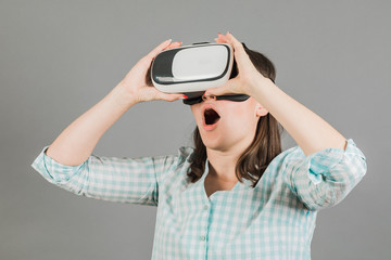 Woman with glasses of virtual reality. Future technology concept.  On a gray background.