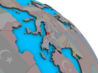 Montenegro with embedded national flag on simple blue political 3D globe.