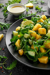 Pineapple Cucumber salad with wild green rocket, lime and olive oil. Healthy juicy food