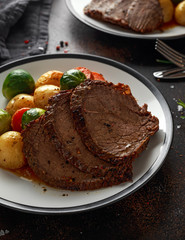 Sliced Roast beef with honey glazed vegetables, served on plate. festive dinner