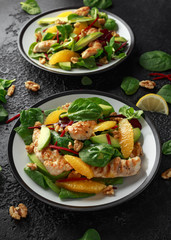 Grilled chicken with orange and avocado salad on rustic background