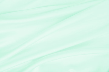 Smooth elegant green silk or satin luxury cloth texture as abstract background. Luxurious background design